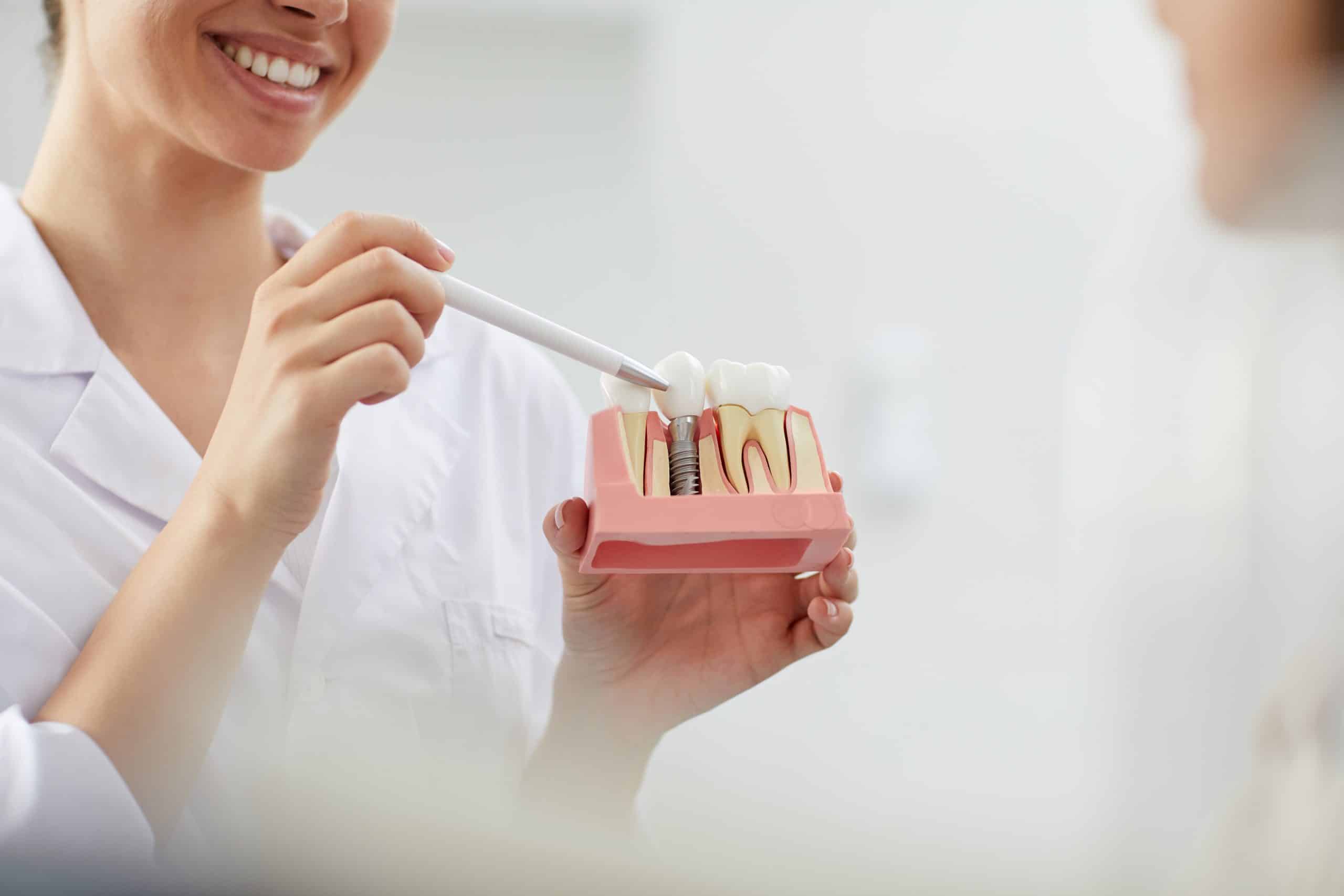 dr chicas pointing to a dental implant model during a restoration dental appointment at  Prosper Dental Studio in Cornelius, NC